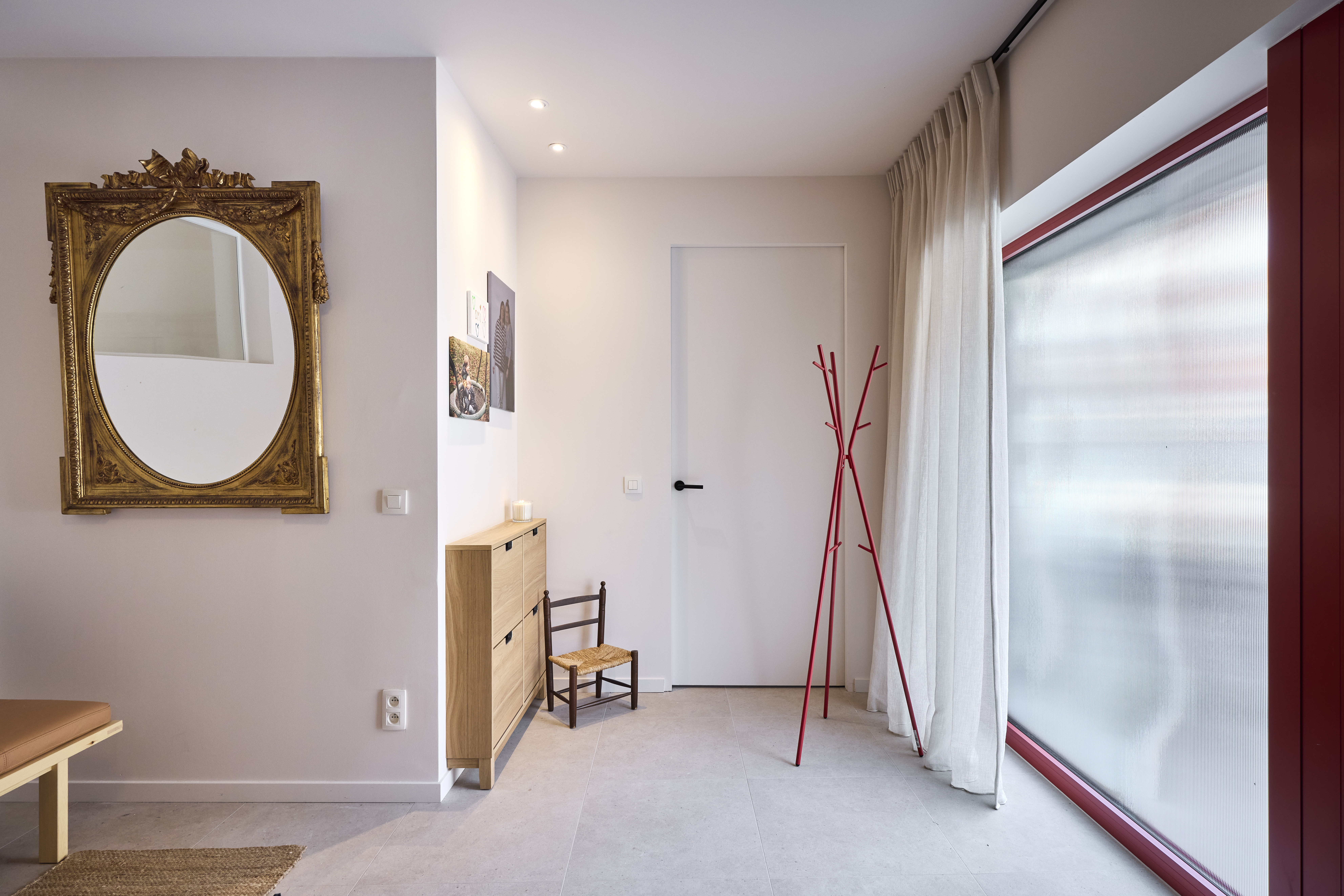 Groot vast raam uit de Komfort EVO small-reeks met Visio Sun-beglazing van Saint-Gobain en rode raamprofielen in een lichte woonkamer.