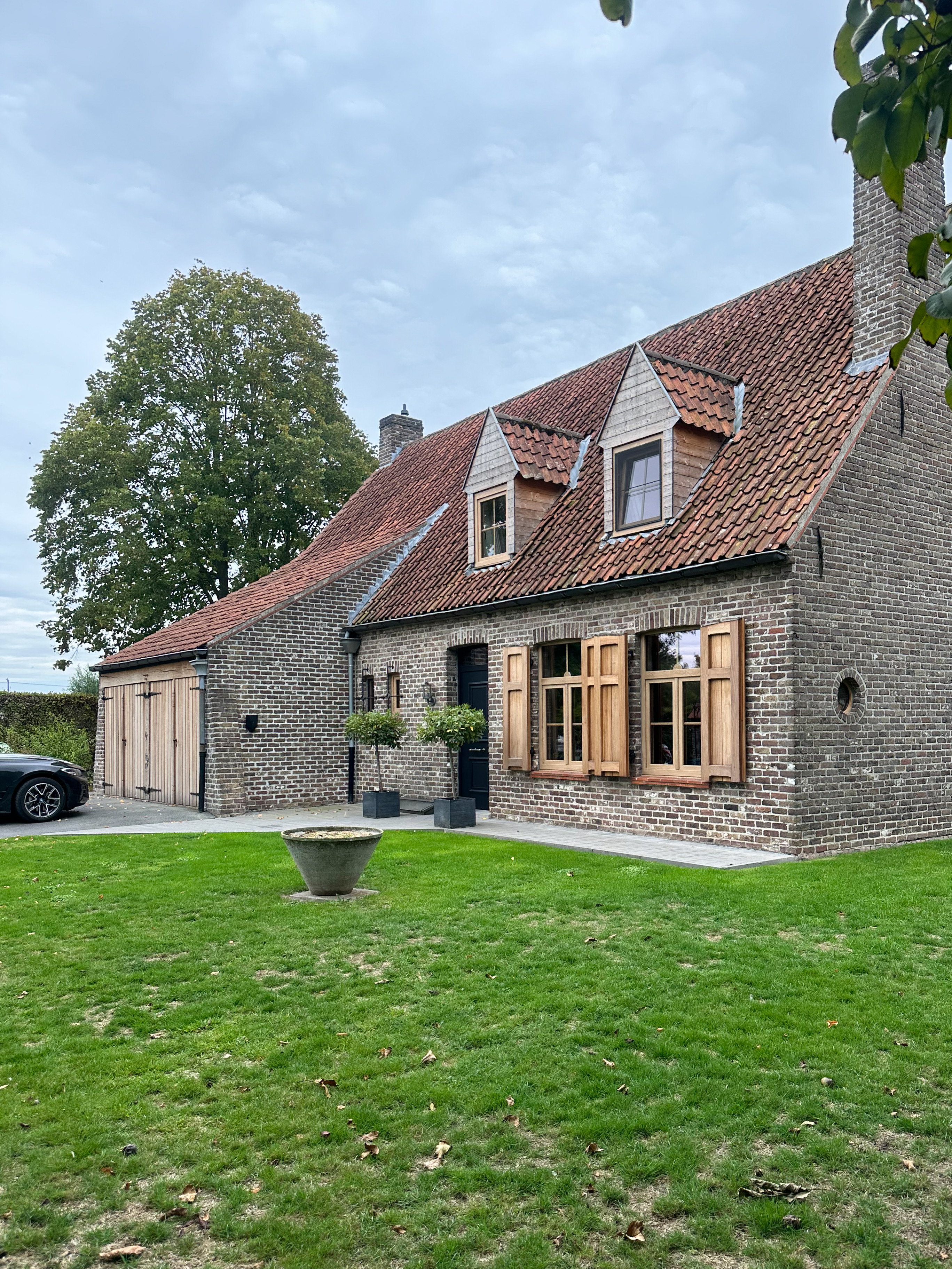 Historisch bakstenen huis met Woodec-ramen in natuurlijke eikenkleur: dubbele ramen, draai-kipramen en een raam met bovenlicht aan de gevel.