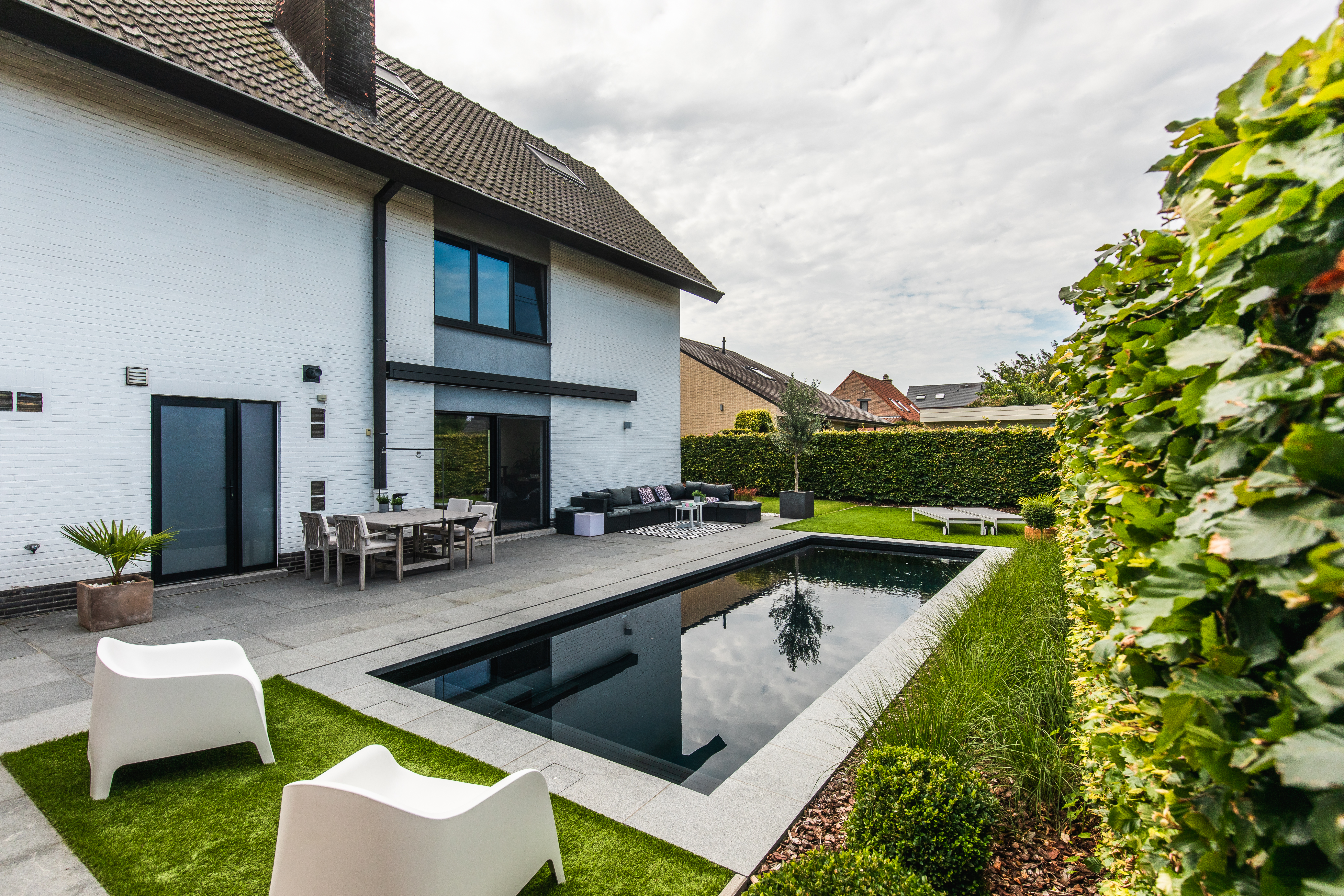 Gerenoveerde vrijstaande woning met zwarte aluminiumramen, driedubbele beglazing, draai-kipramen en een beglaasde deur naar het terras naast het zwembad.