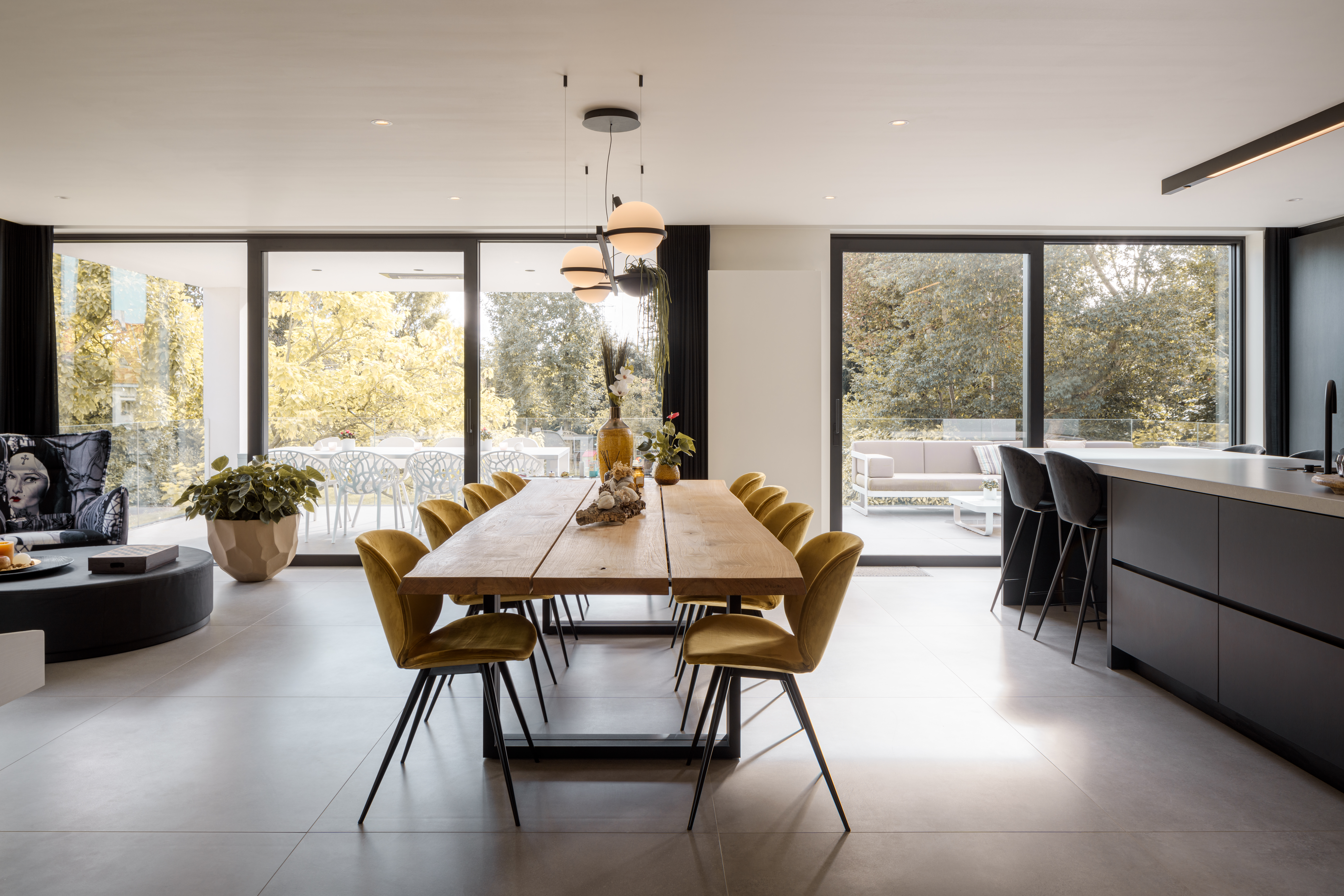 Modern interieur van een nieuwbouwwoning met zwart ALU Visoglide Monorail-schuifraam, grote glaspartijen, keuken en eetruimte.