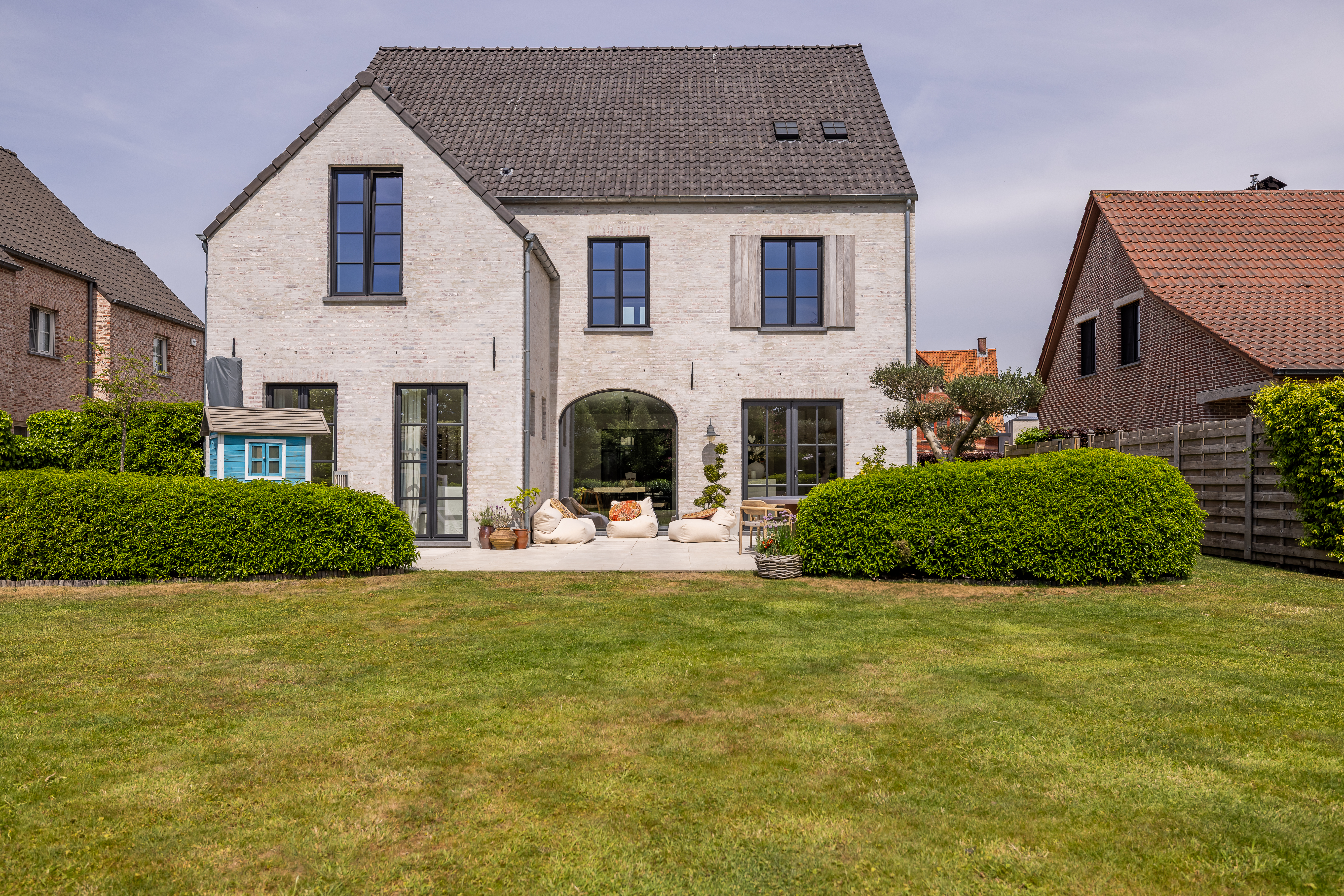 Warm landelijk nieuwbouwhuis in open bebouwing met donkere Steellook PLUS small-raamprofielen, vaste ramen en draai-kip- en dubbele ramen aan de tuinzijde.