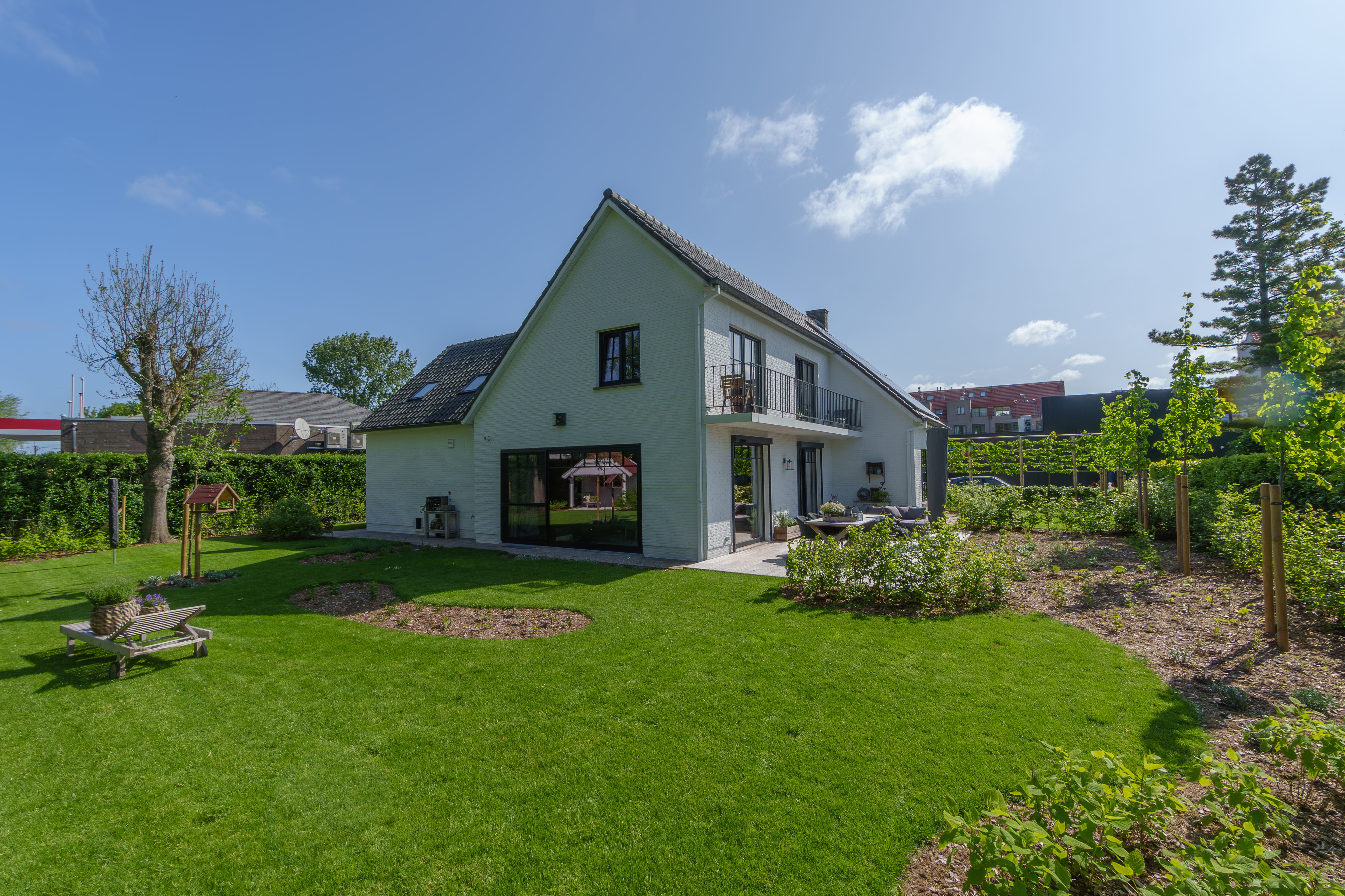 Gerenoveerde vrijstaande woning met matzwarte Impakt PLUS-ramen, waaronder een vast raam en een dubbel raam, in een warme landelijke tuin.