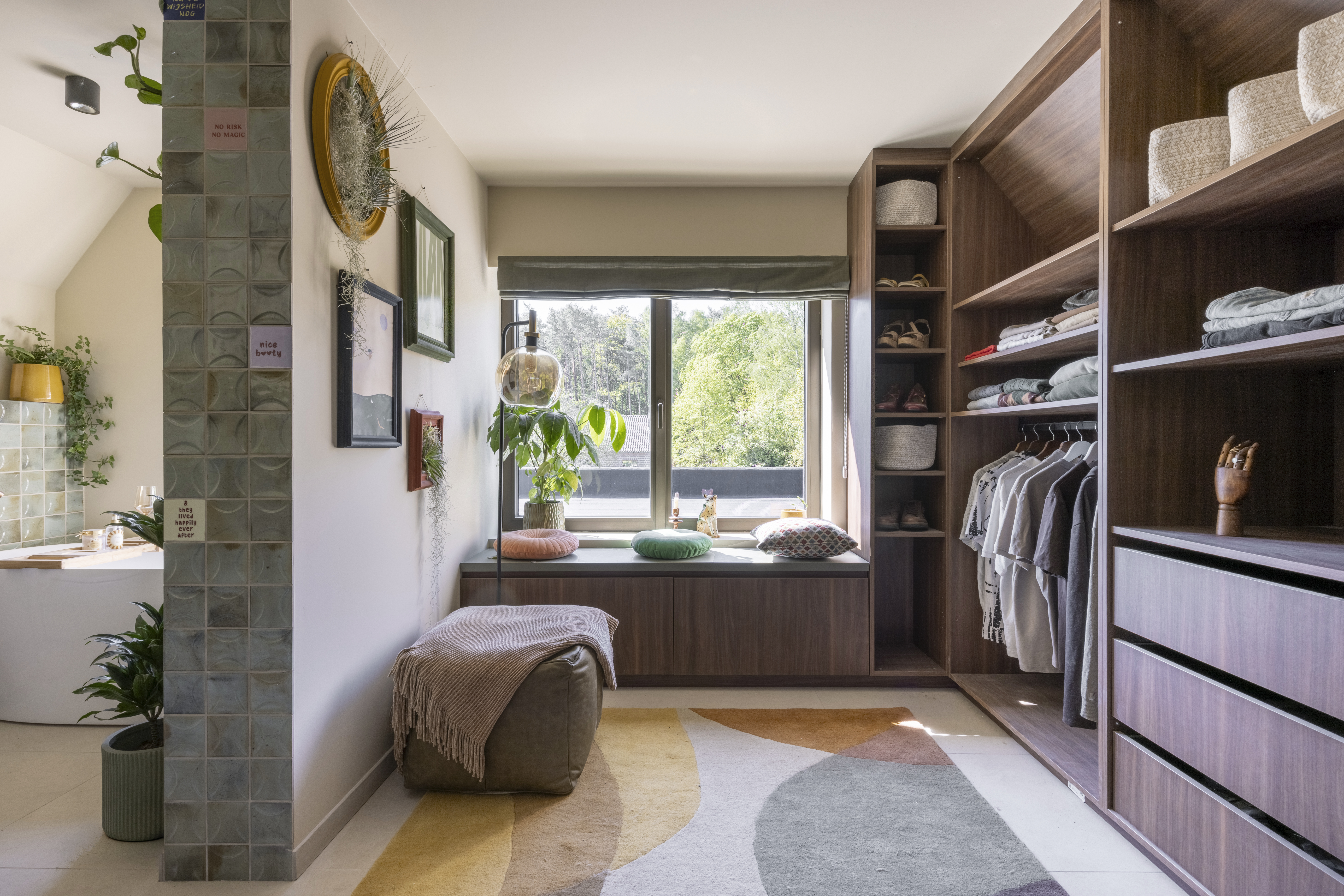 Lichte dressing met een dubbel draai-kipraam Komfort EVO small in C33-bronsanodisatie, ingebouwde kasten, een zitbank en uitzicht op het groen.