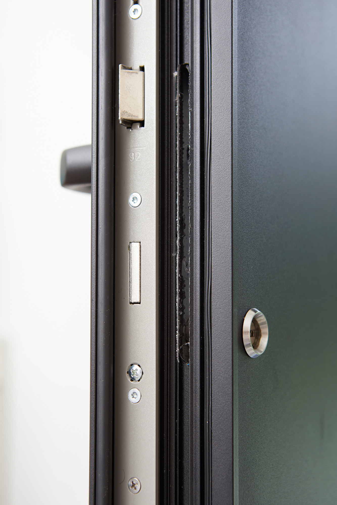 Close-up van een modern zwart Steellook-deurprofiel met zichtbaar slot, sluitplaat en ronde cilinder, met een karaktervolle, moderne uitstraling.