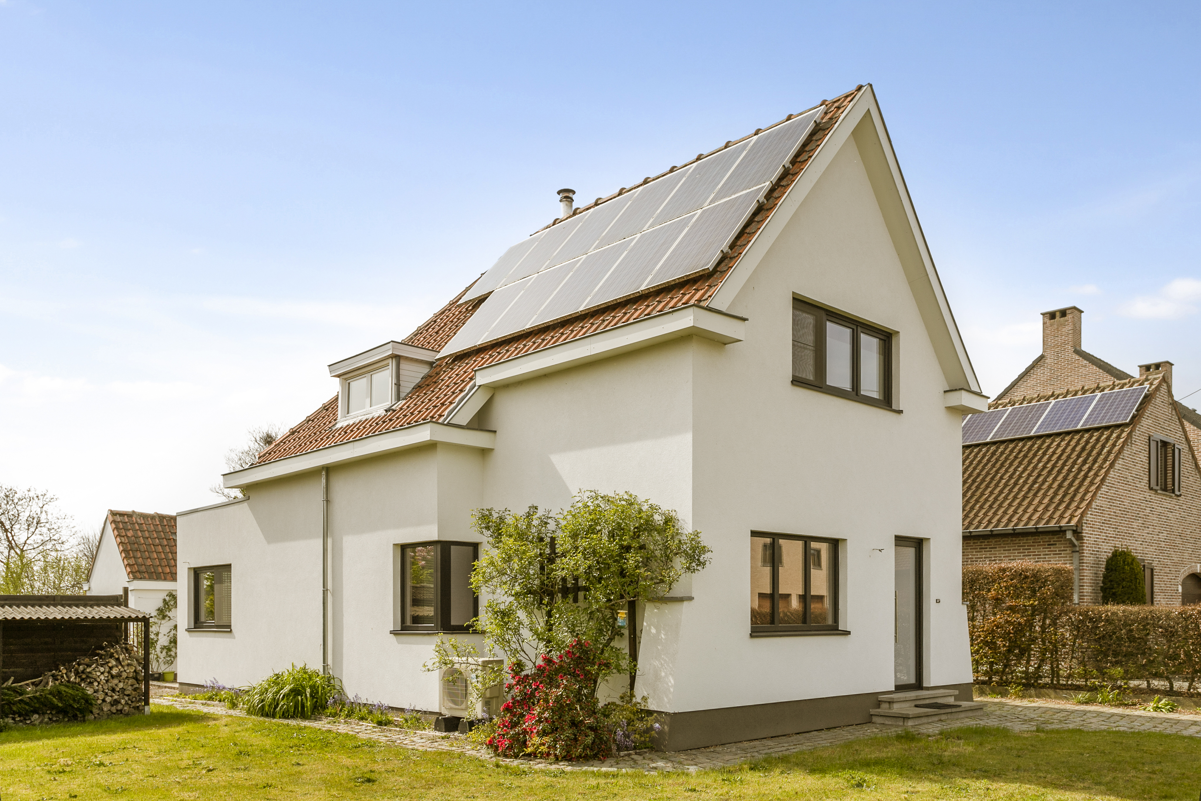 Gerenoveerde open bebouwing met matzwarte PVC-raamprofielen, driedubbele beglazing, draai-kipramen en een beglaasde deur in een rustige woonomgeving.