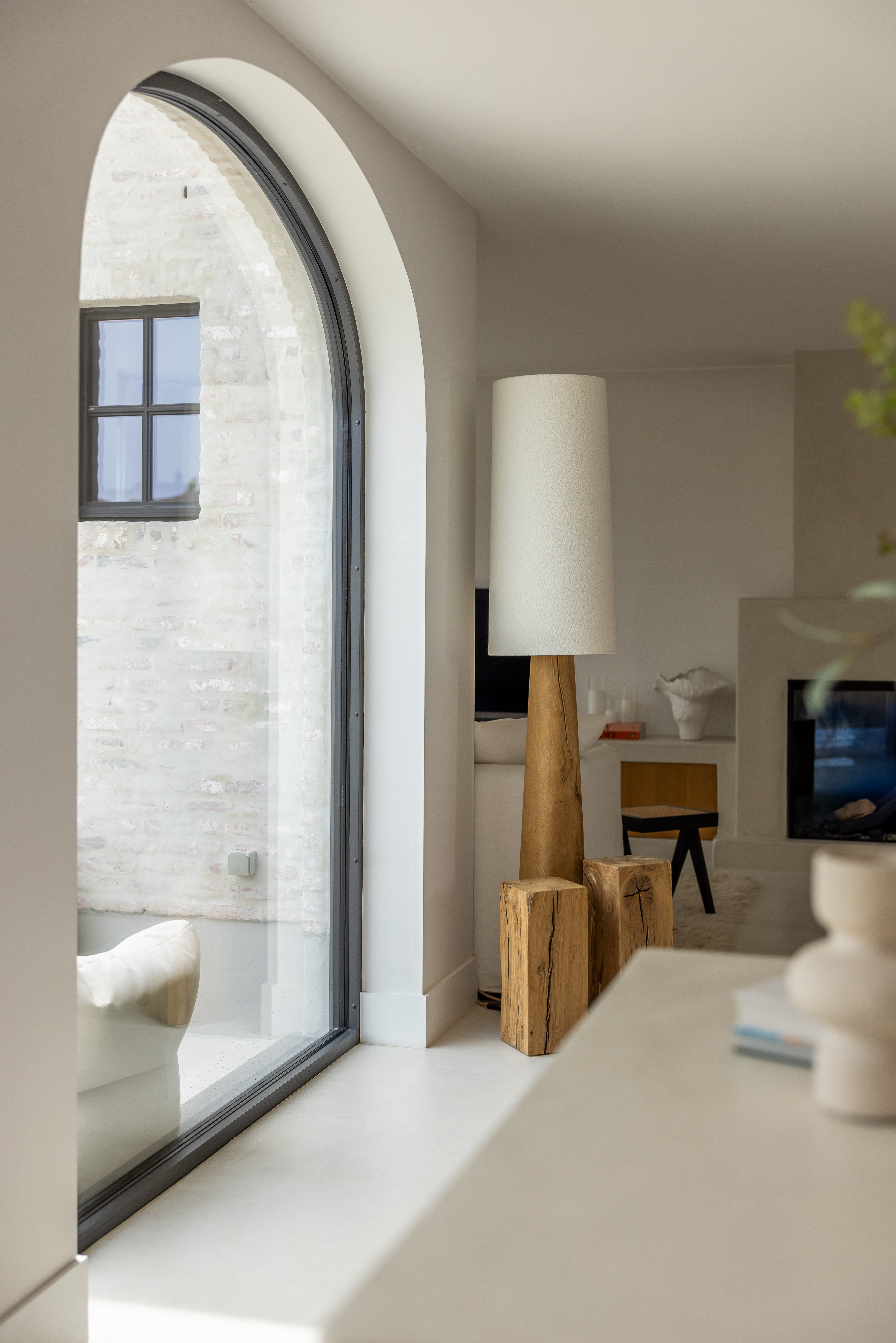 Hoog vast raam met ronde boog en slanke Steellook PLUS small-profielen, in een warm landelijk interieur van een nieuwbouwwoning.