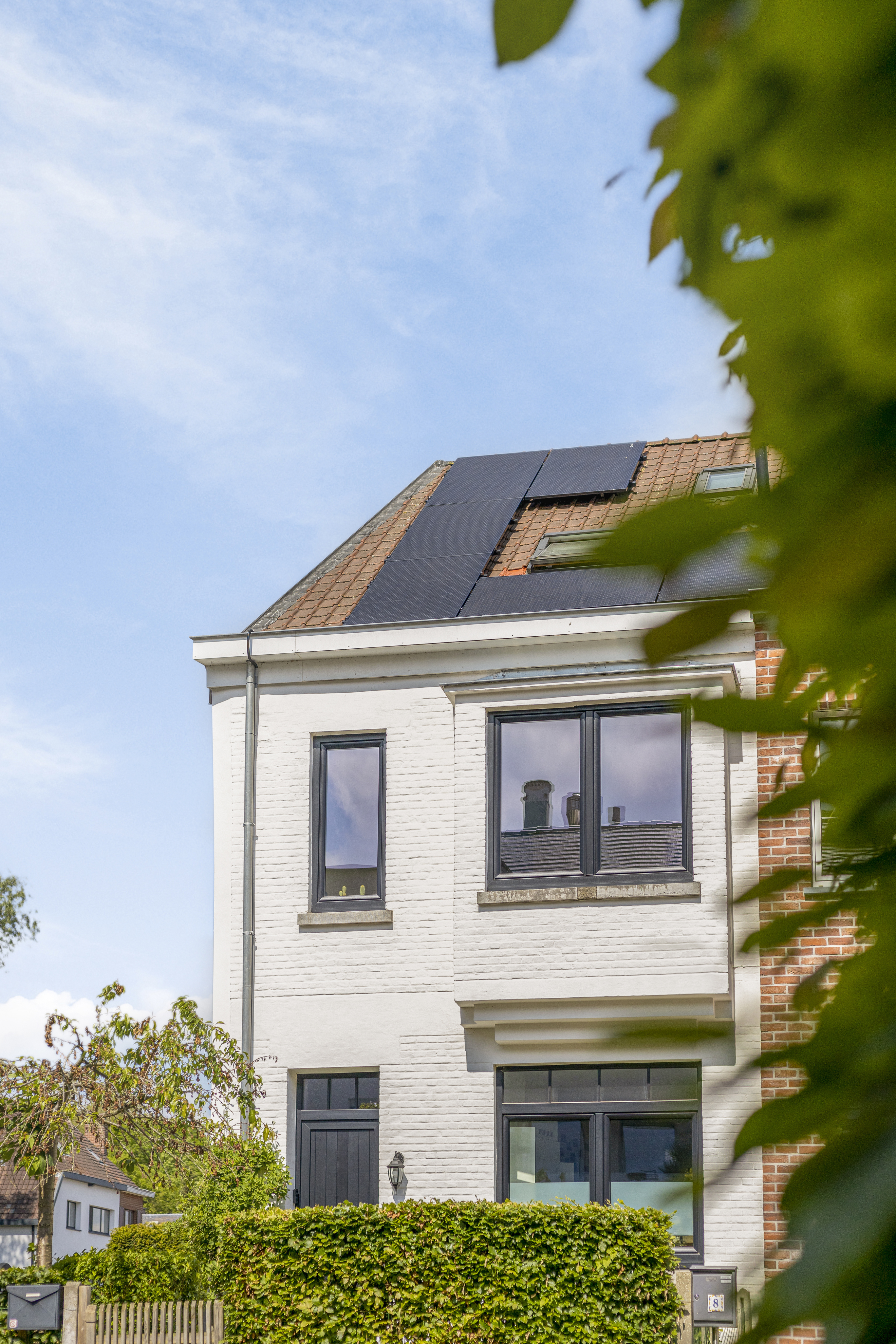 Gerenoveerde woninggevel met zwarte matte PVC-ramen van het type Impakt PLUS, waaronder draai-kipramen en een raam met bovenlicht.