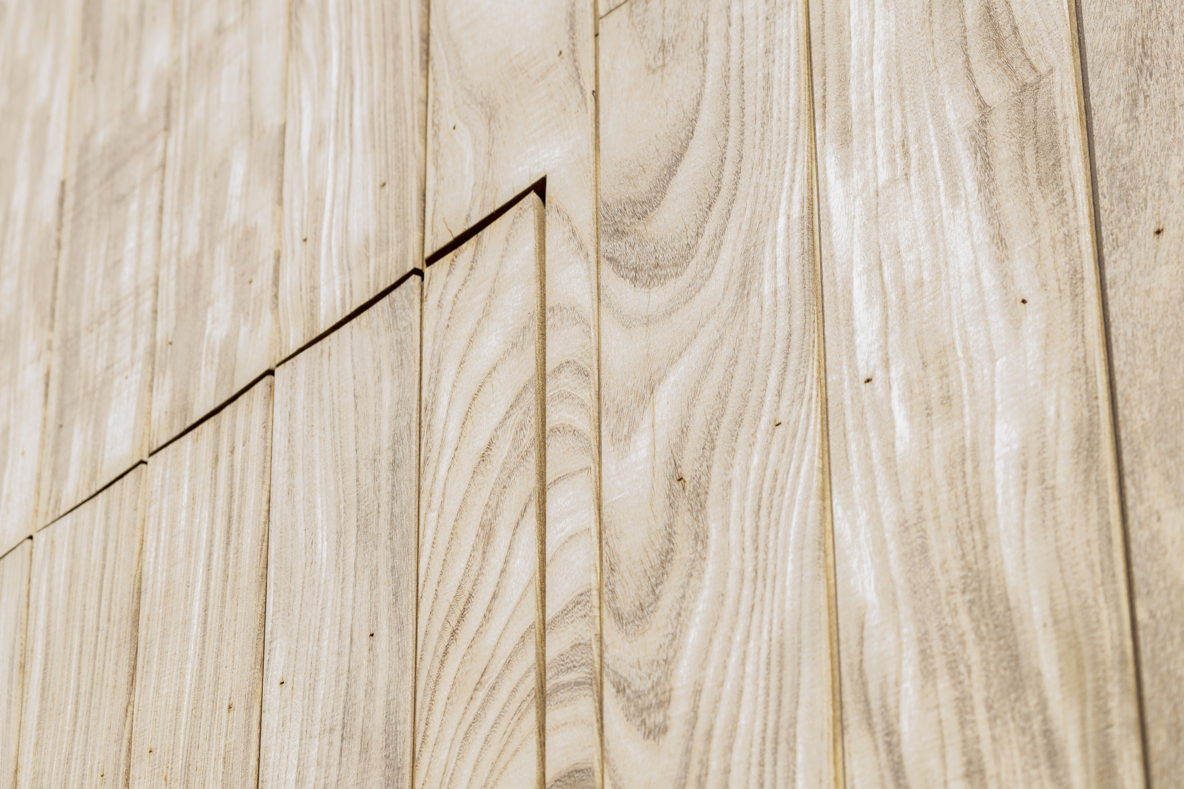 Lichte verticale houten wandbekleding met zichtbare houtnerf en fijne voegen brengt een warme, landelijke sfeer in het interieur.