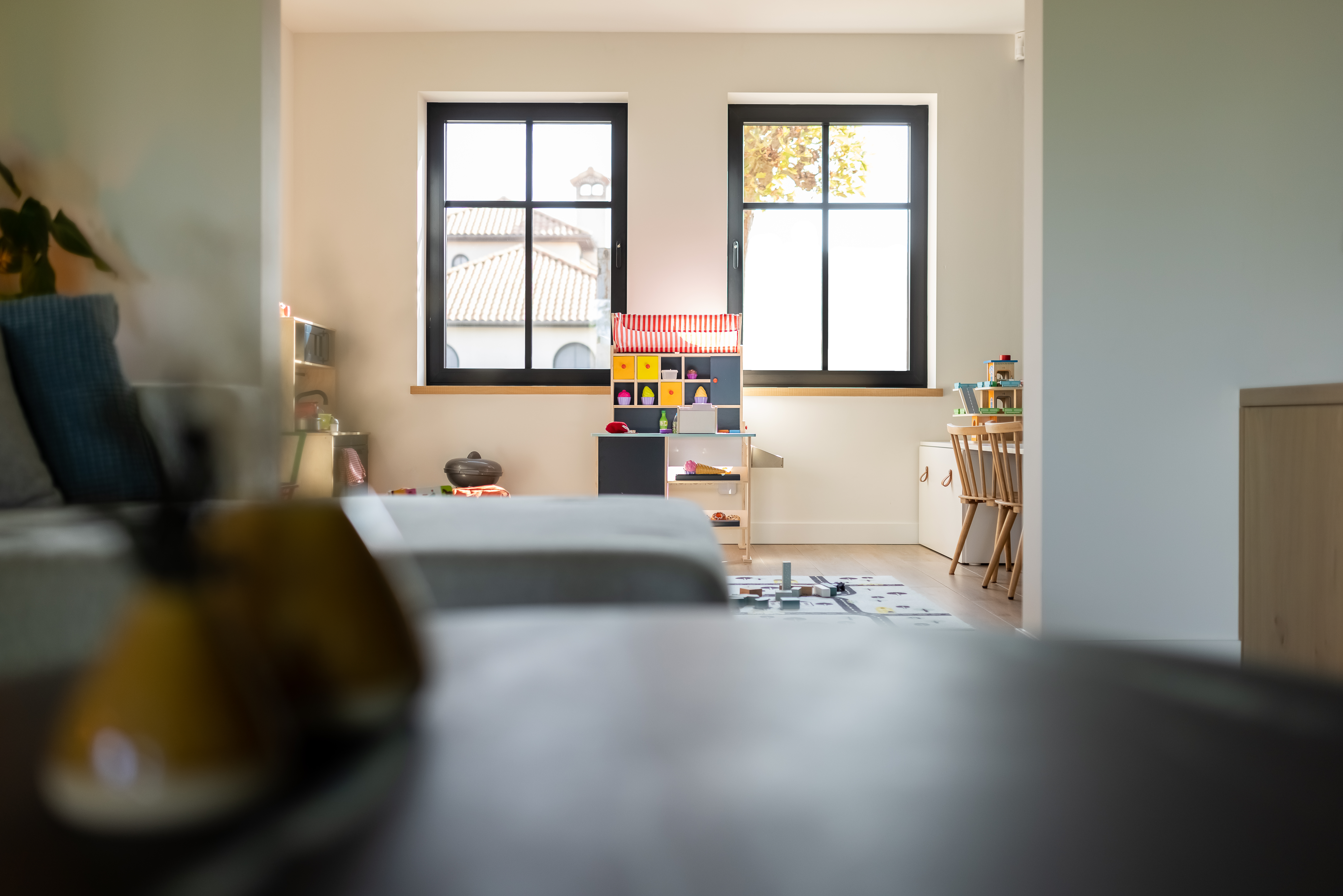 Warm landelijk interieur in een nieuwbouwwoning met twee zwarte Steellook PLUS small-ramen in een lichte leefruimte.
